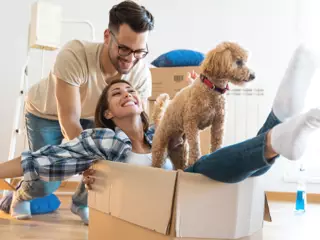 Couple with dog unpacking in rental suite